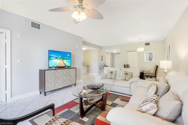 a living room with furniture a rug and a flat screen tv