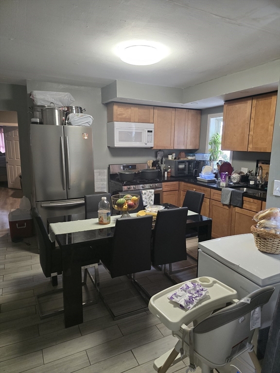184 Myrtle Street Brockton, MA 02301 - Photo 4 of 10 a kitchen with a table chairs and a stove