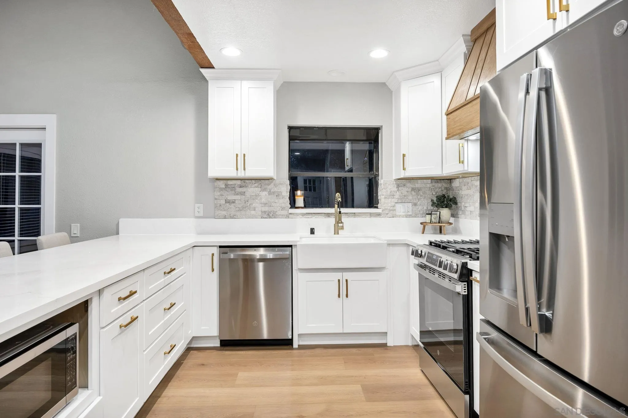 1590 Dorothea Avenue Fallbrook, CA 92028 - Photo 7 of 42 a kitchen with white cabinets and stainless steel appliances