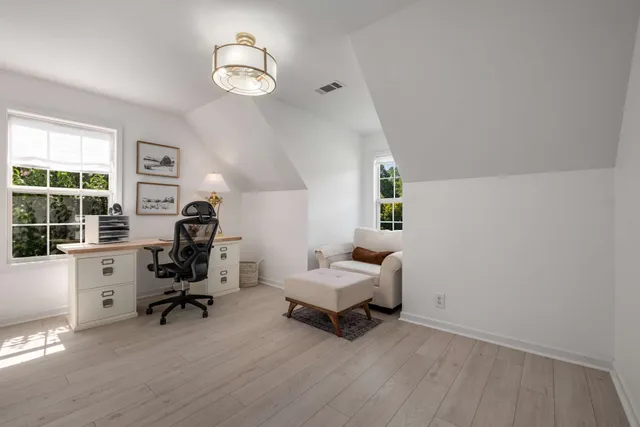 a view of a workspace with furniture and a window