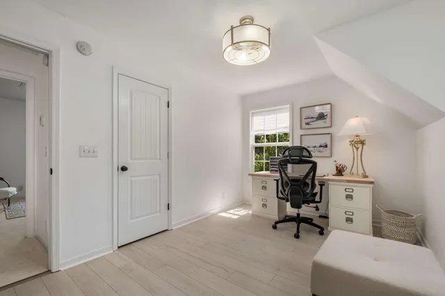a view of a workspace with furniture and a window
