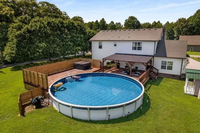 a view of swimming pool with seating area and lake view