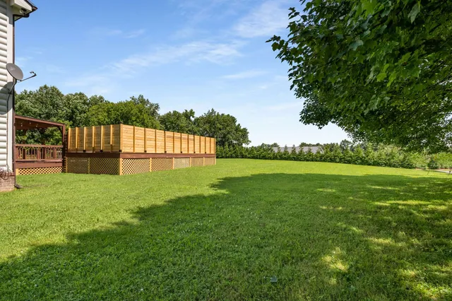 a view of house with yard and green space