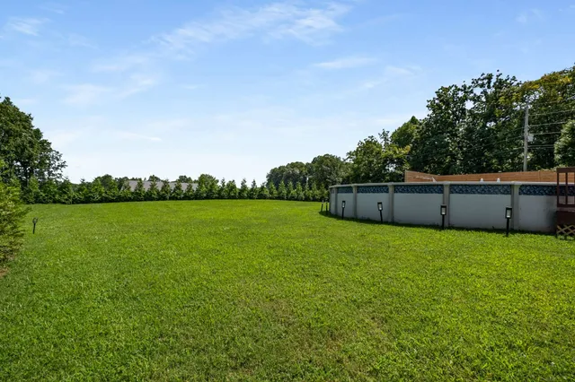 a view of a house with a small yard and wooden fence