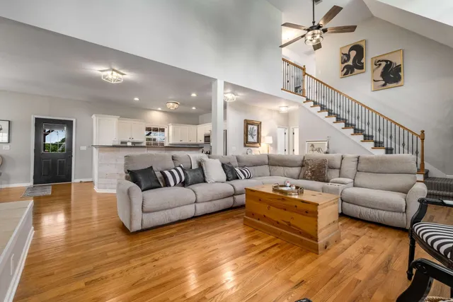 a living room with furniture kitchen view and a wooden floor