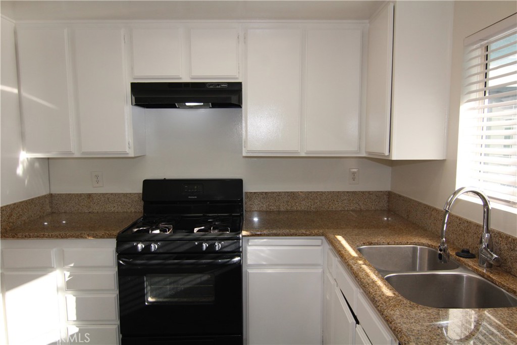 a kitchen with a sink a stove and cabinets