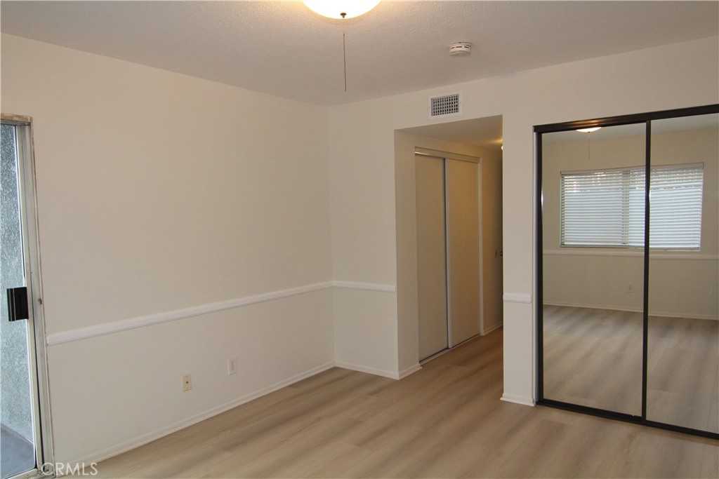 955 East 3rd Street, Unit 204 Long Beach, CA 90802 - Photo 20 of 37 an empty room with wooden floor and mirror