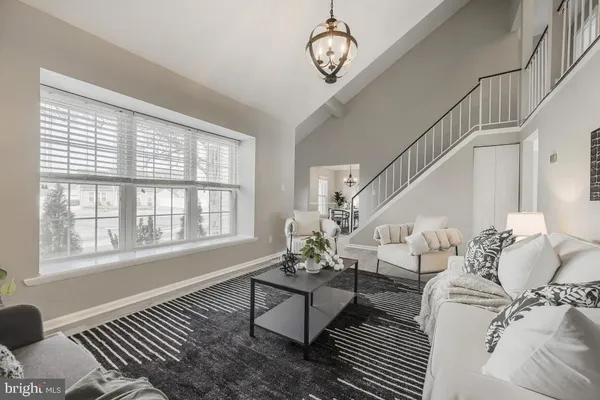 a living room with furniture chandelier and a window