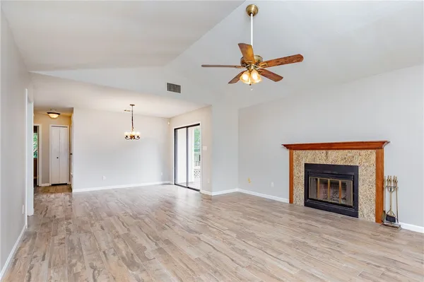 a view of an empty room with a fireplace and a window