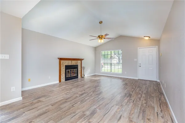 wooden floor fireplace and windows in an empty room