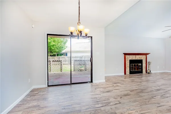 a view of a room with wooden floor fireplace and windows
