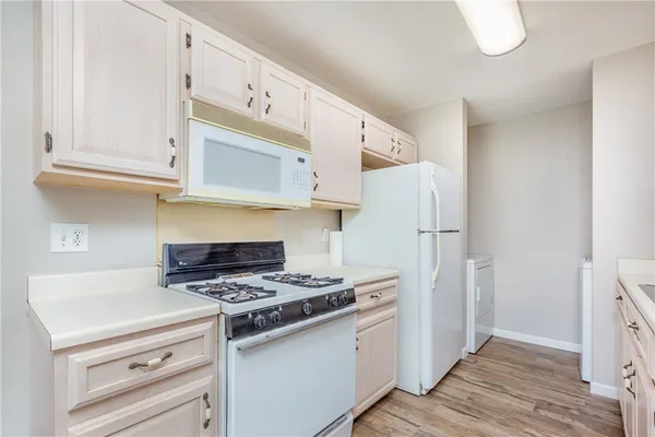 a kitchen with white cabinets and white appliances