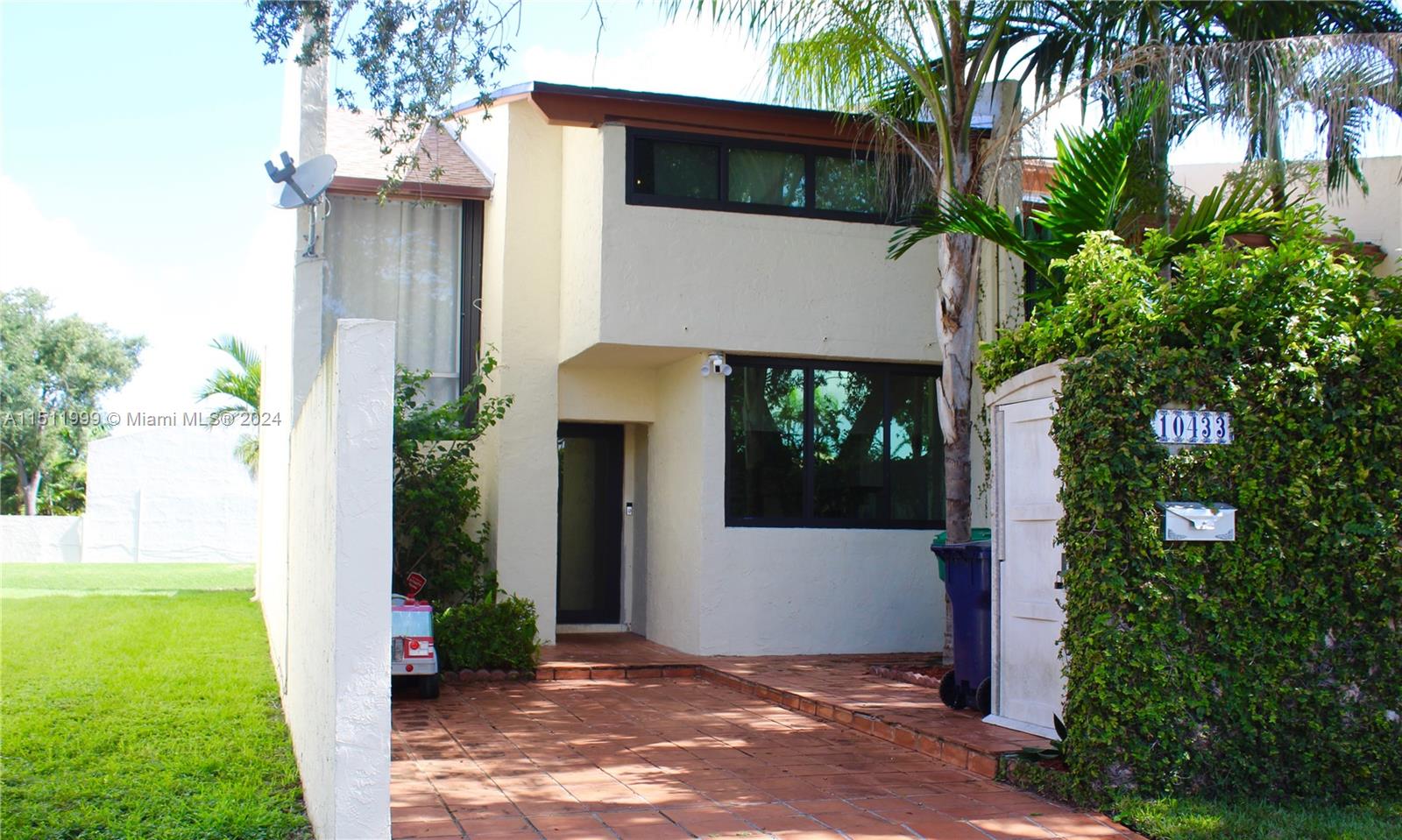 10433 Southwest 80th Street Miami, FL 33173 - Photo 1 of 24 a front view of a house with garden