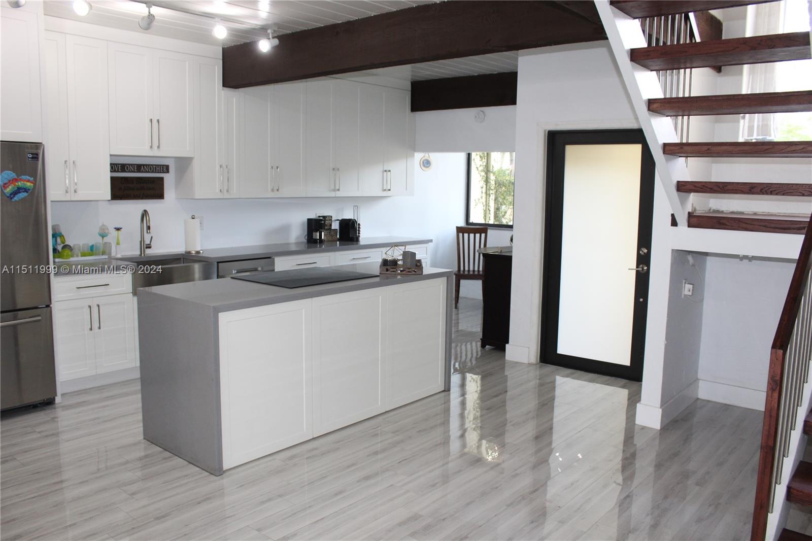 10433 Southwest 80th Street Miami, FL 33173 - Photo 2 of 24 a kitchen with stainless steel appliances granite countertop a refrigerator a sink a stove and white cabinets with wooden floor