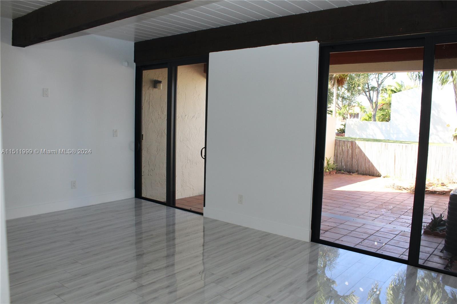 10433 Southwest 80th Street Miami, FL 33173 - Photo 7 of 24 a view of an empty room with wooden floor and a window