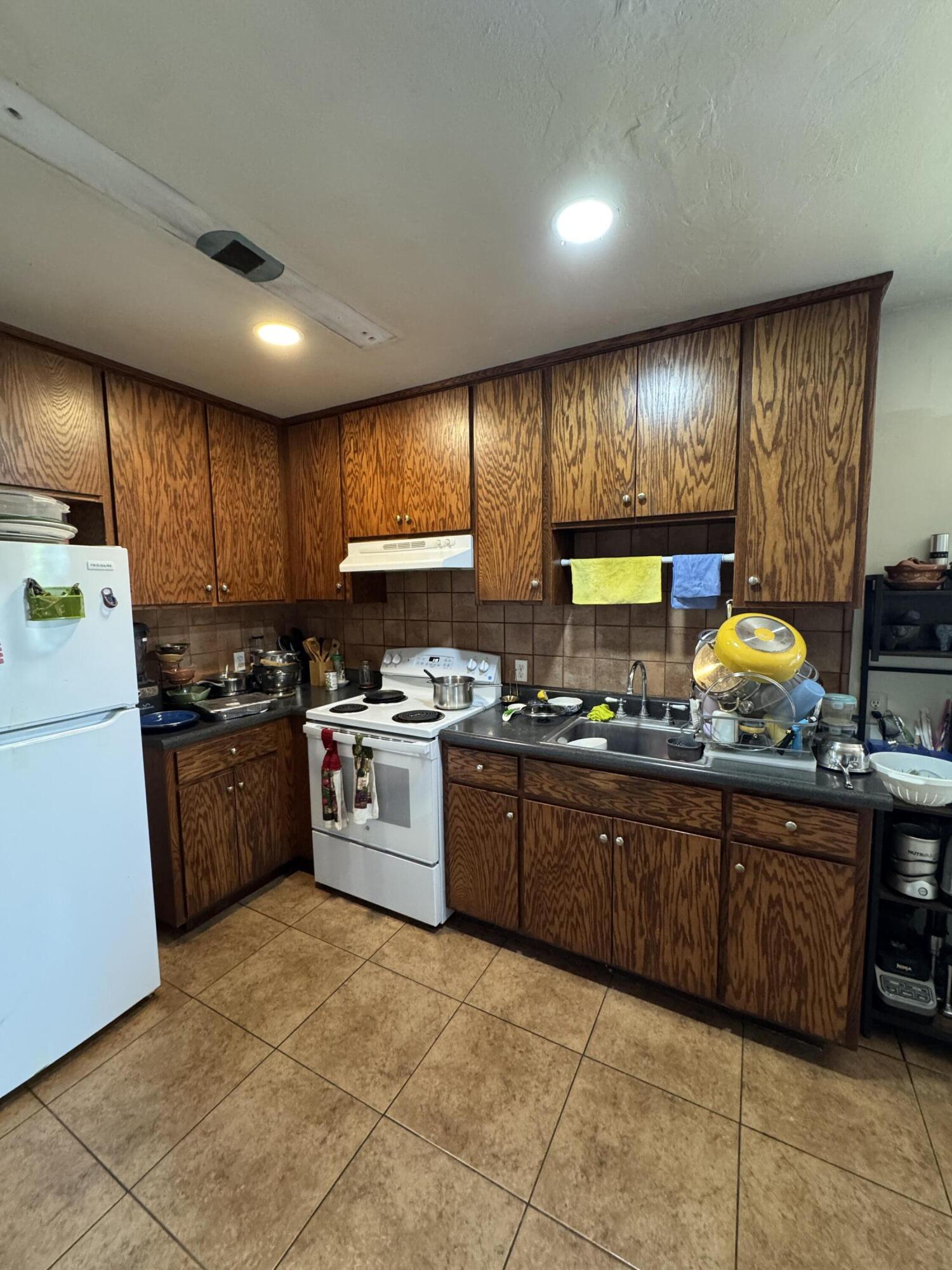 704 North Floral Street Visalia, CA 93291 - Photo 15 of 51 a kitchen with stainless steel appliances granite countertop wooden cabinets a stove top oven a sink and dishwasher