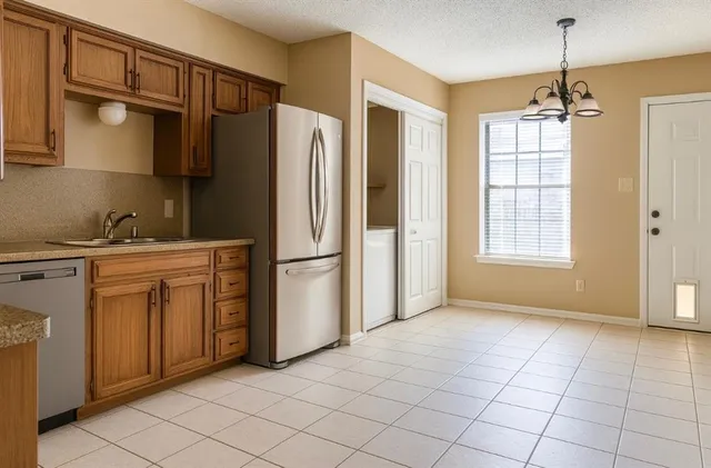 a kitchen with stainless steel appliances a refrigerator sink and cabinets