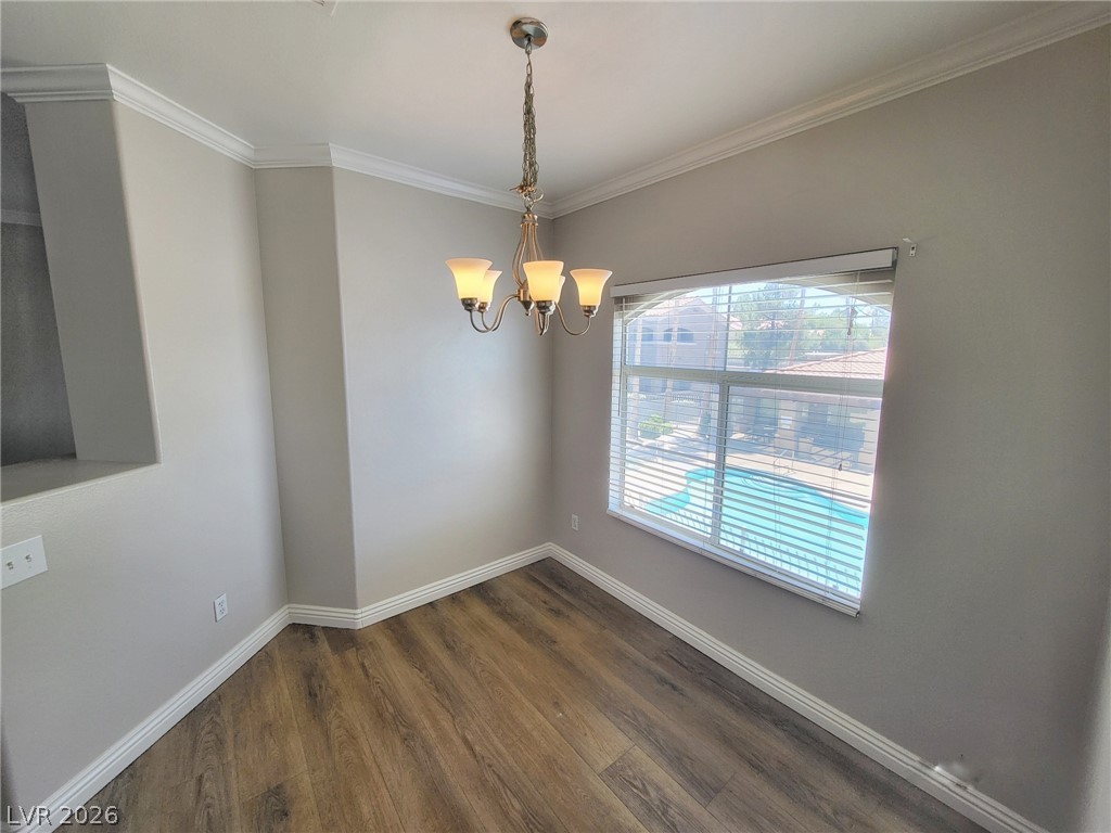 5525 West Flamingo Road, Unit 2040 Las Vegas, NV 89103 - Photo 6 of 15 Hardwood-style flooring and crown molding define this versatile interior space with a pool view.
