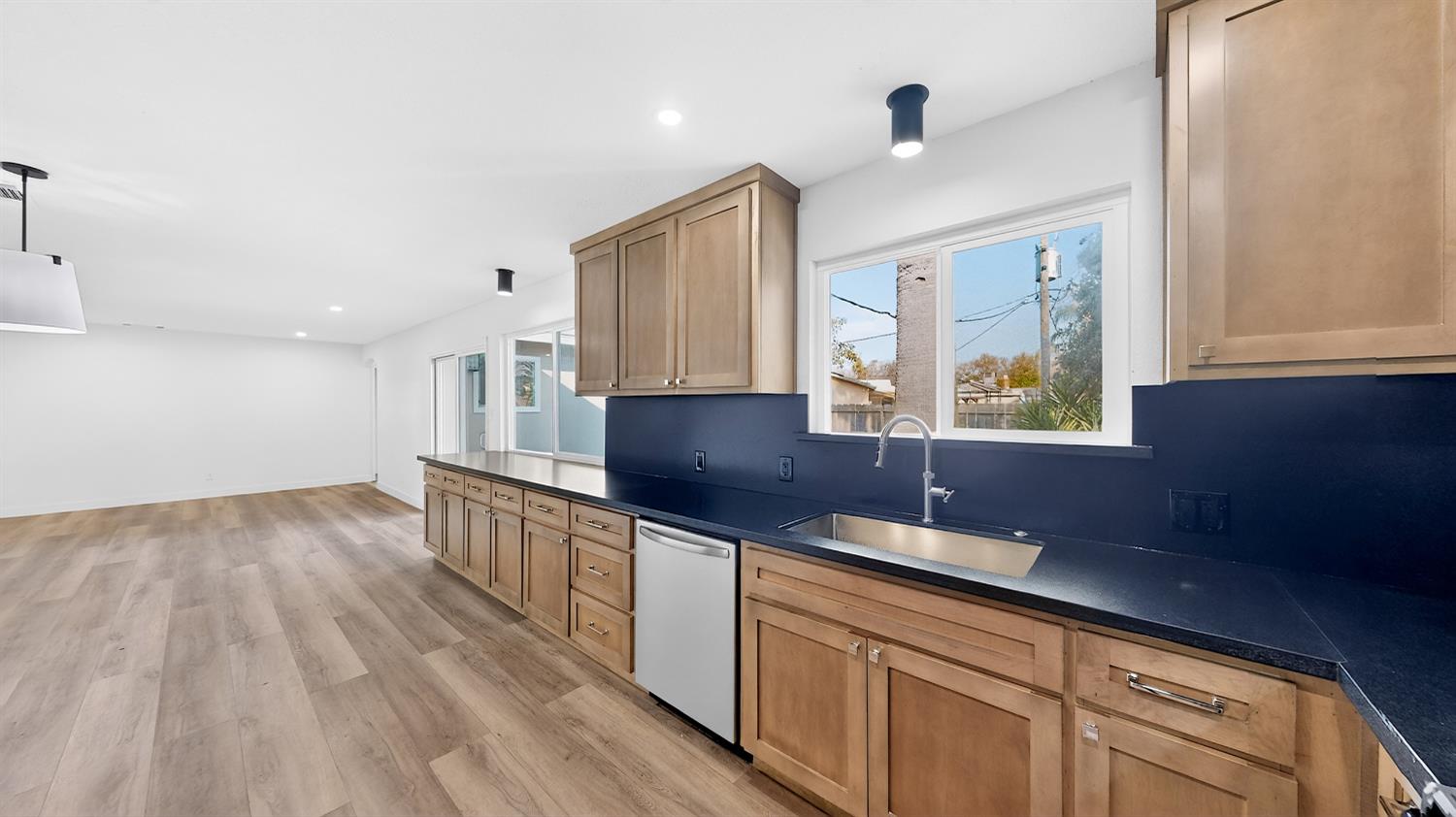 1611 East Olive Avenue Merced, CA 95340 - Photo 19 of 43 a kitchen with stainless steel appliances a sink cabinets and wooden floor