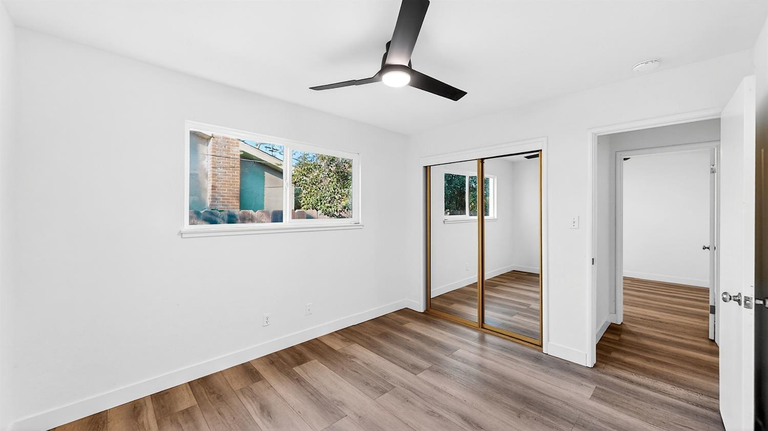 1611 East Olive Avenue Merced, CA 95340 - Photo 23 of 43 a view of an empty room with wooden floor and a window
