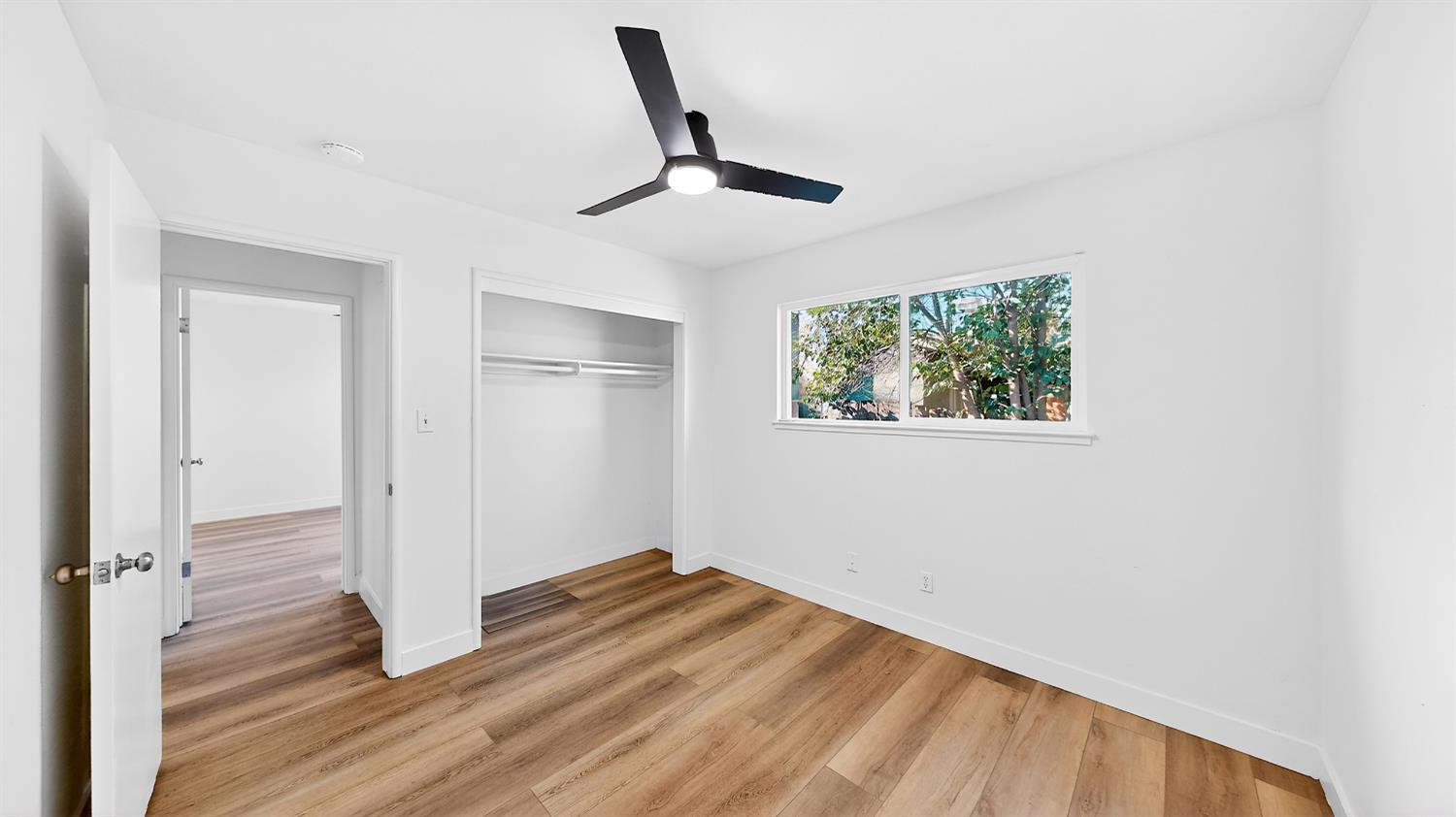 1611 East Olive Avenue Merced, CA 95340 - Photo 25 of 43 a view of a livingroom with wooden floor and a ceiling fan