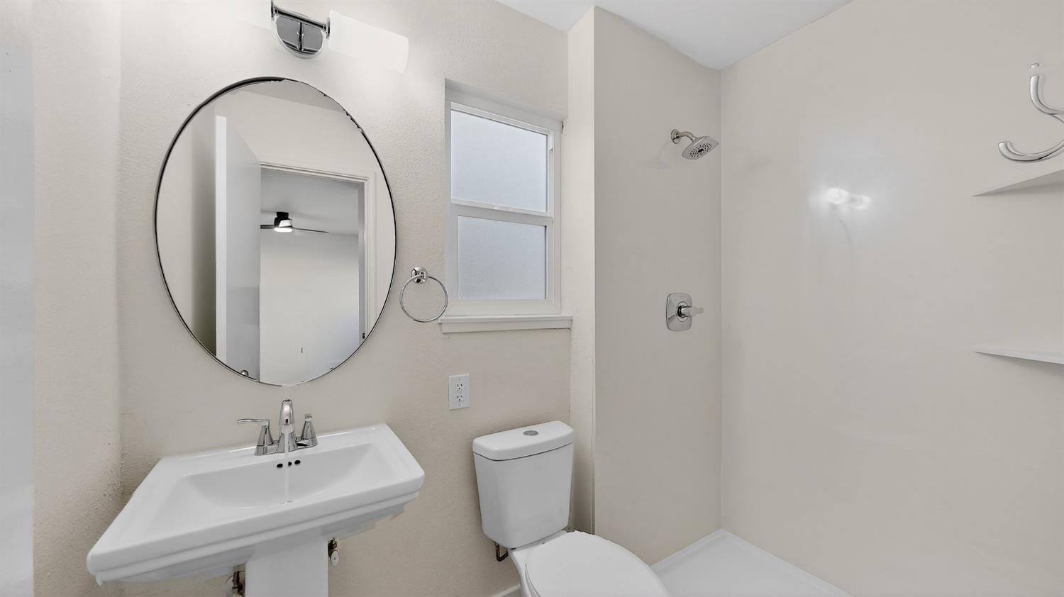 1611 East Olive Avenue Merced, CA 95340 - Photo 30 of 43 a bathroom with a toilet a sink and a mirror