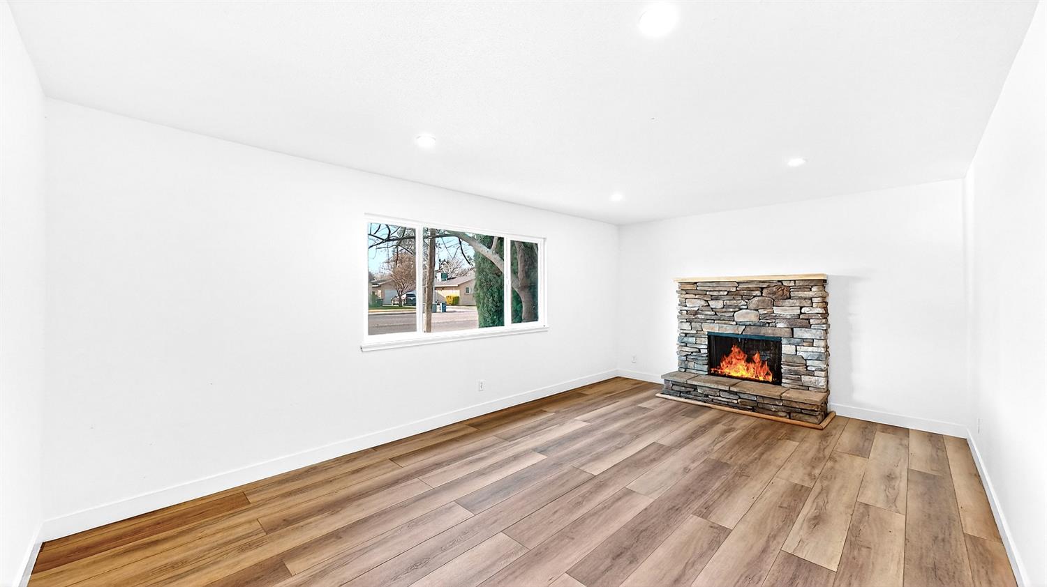 1611 East Olive Avenue Merced, CA 95340 - Photo 10 of 43 a view of an empty room with a fireplace and a window