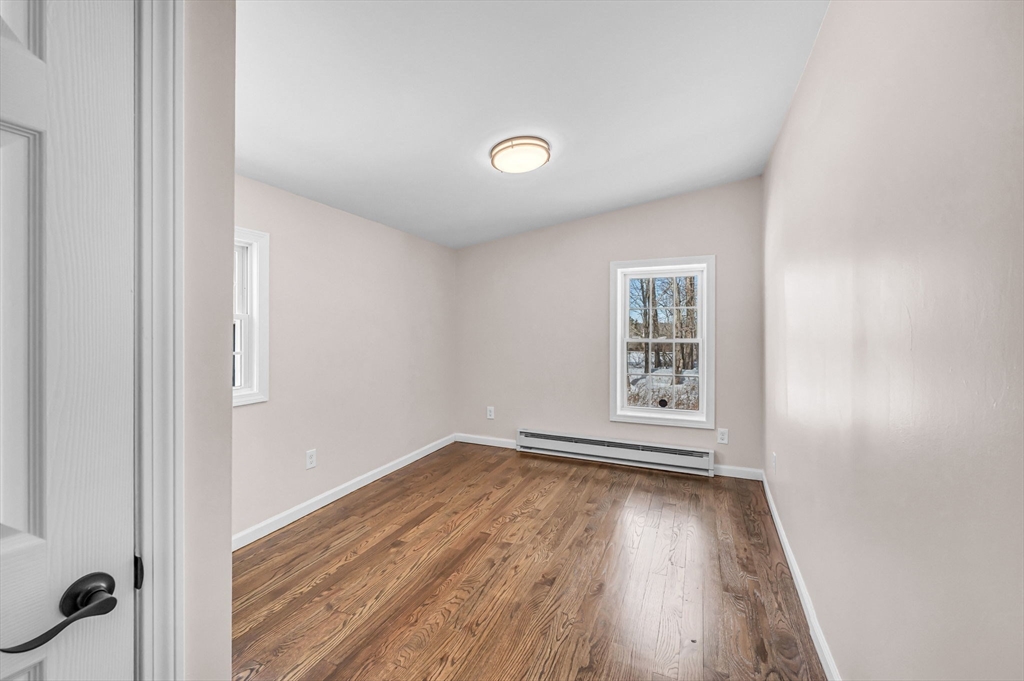 338 Daniel Shays Highway Pelham, MA 01002 - Photo 20 of 41 an empty room with wooden floor and windows