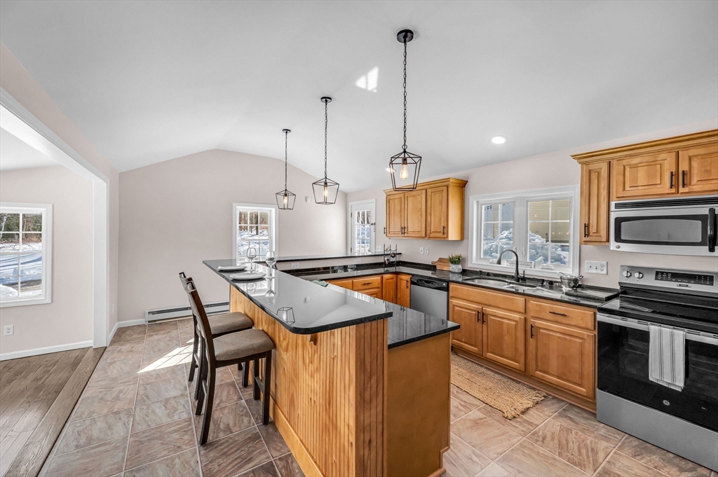 338 Daniel Shays Highway Pelham, MA 01002 - Photo 5 of 41 a kitchen with stainless steel appliances granite countertop a kitchen island a stove a sink a dining table and chairs
