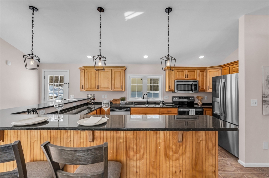 338 Daniel Shays Highway Pelham, MA 01002 - Photo 6 of 41 a kitchen with stainless steel appliances granite countertop a stove a kitchen island a refrigerator and a sink