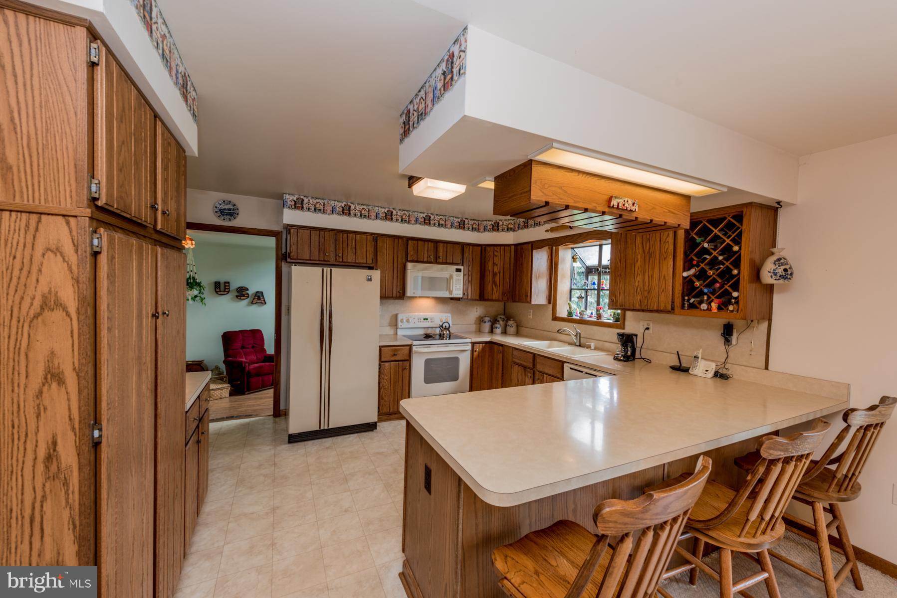 4414 Salem Bottom Road Westminster, MD 21157 - Photo 8 of 30 a kitchen with a table chairs refrigerator and cabinets