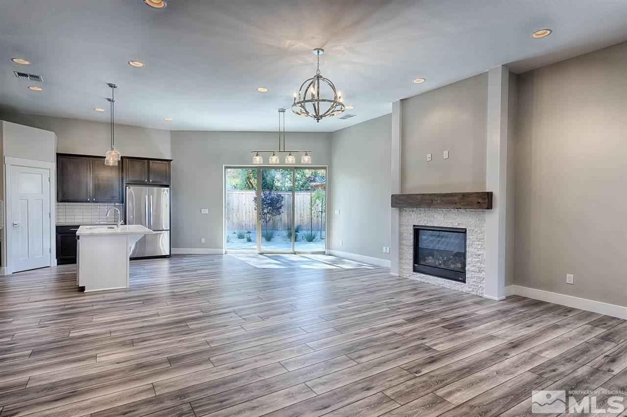 1364 Charles Drive Reno, NV 89509 - Photo 3 of 18 a view of a kitchen and an empty room with wooden floor and a fireplace