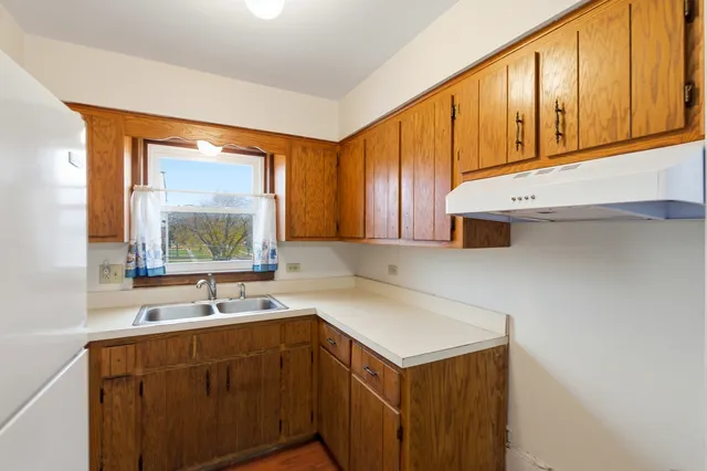 a kitchen with a sink a refrigerator and window