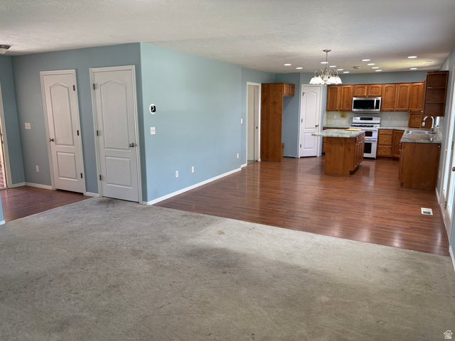 587 West 2400 South Perry, UT 84302 - Photo 13 of 46 Open-concept interior featuring wood-finish flooring in the kitchen, light blue wall paint, and recessed lighting