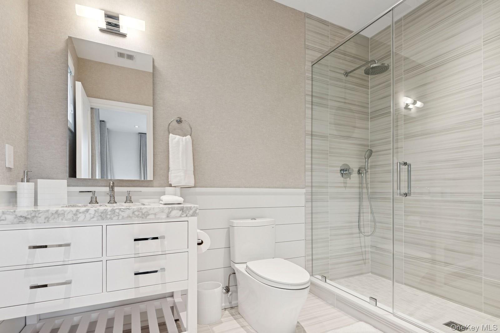 8 Magnolia Drive, Unit 2A Water Mill, NY 11976 - Photo 16 of 39 a bathroom with a granite countertop sink toilet and shower