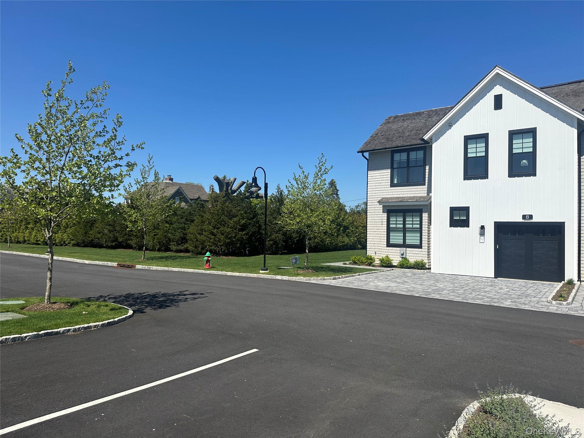 8 Magnolia Drive, Unit 2A Water Mill, NY 11976 - Photo 27 of 39 a front view of a house with a yard and garage