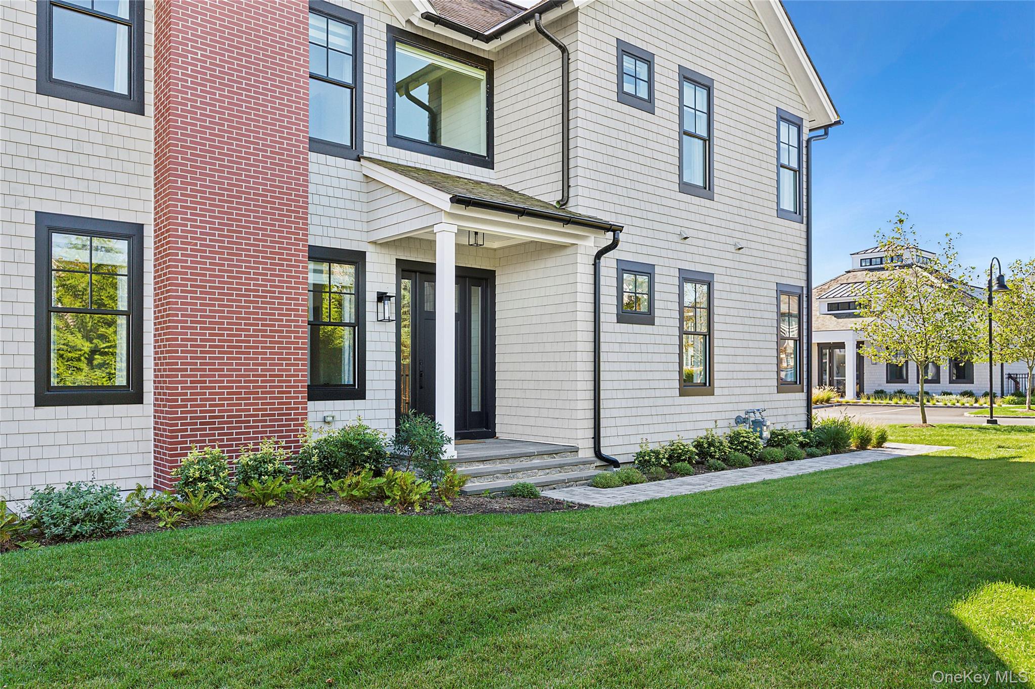8 Magnolia Drive, Unit 2A Water Mill, NY 11976 - Photo 36 of 39 a front view of a house with a garden