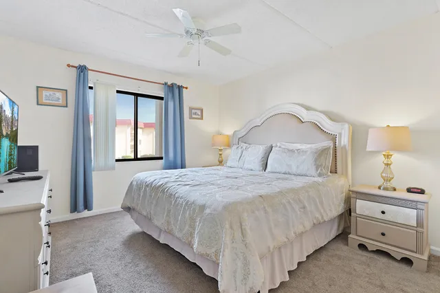 a bedroom with a bed and a flat tv screen on dresser