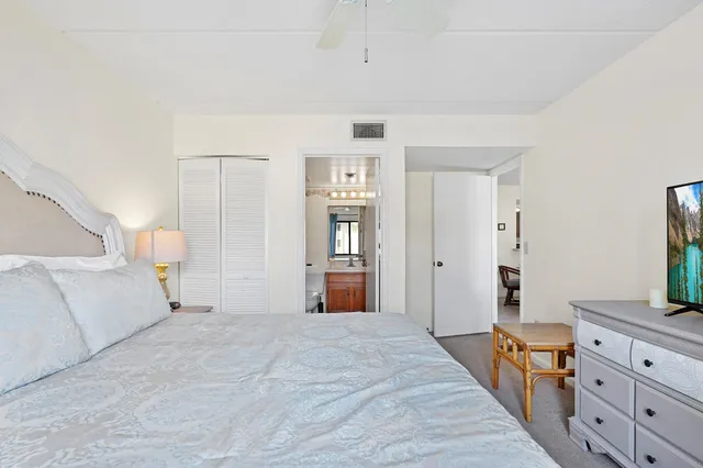 a bedroom with a large bed and a flat tv screen on dresser