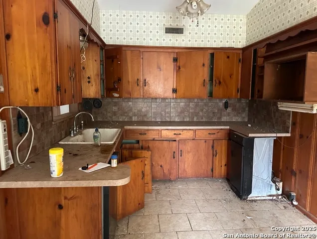 a kitchen with a sink a stove and a wooden cabinets