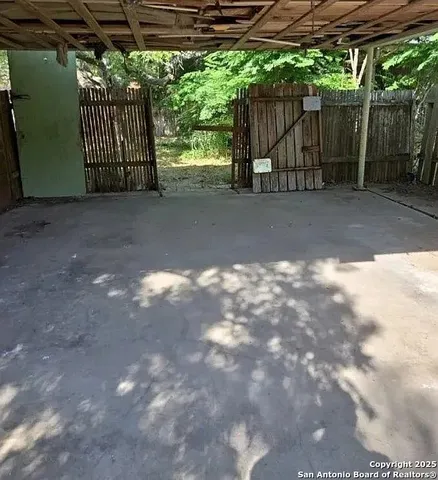a view of a yard with wooden fence