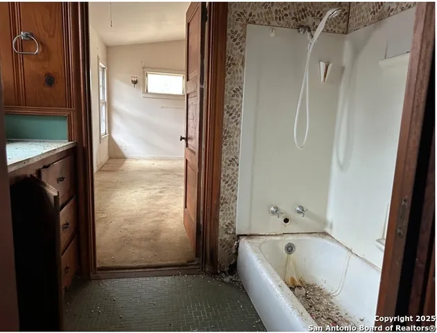a bathroom with a tub a sink and a shower