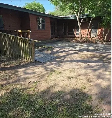 a view of a backyard with table and chairs and wooden fence