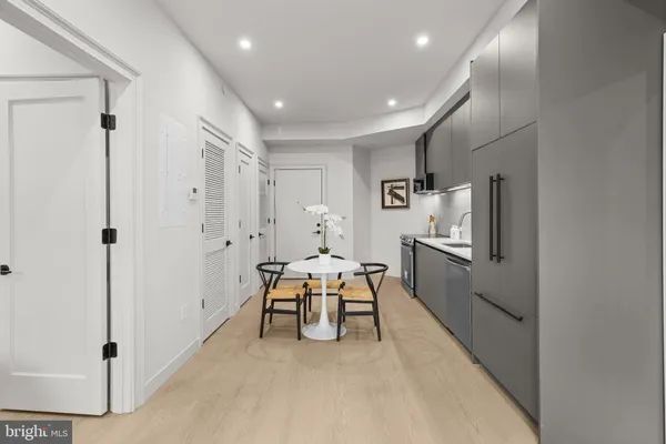 a living room with furniture a large window and stainless steel appliances
