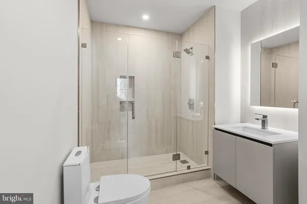 a bathroom with a granite countertop sink toilet and shower