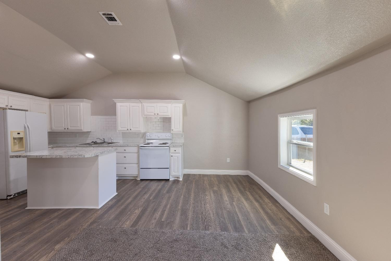 506 40th Street Lubbock, TX 79404 - Photo 4 of 17 a kitchen with white cabinets and wooden floor