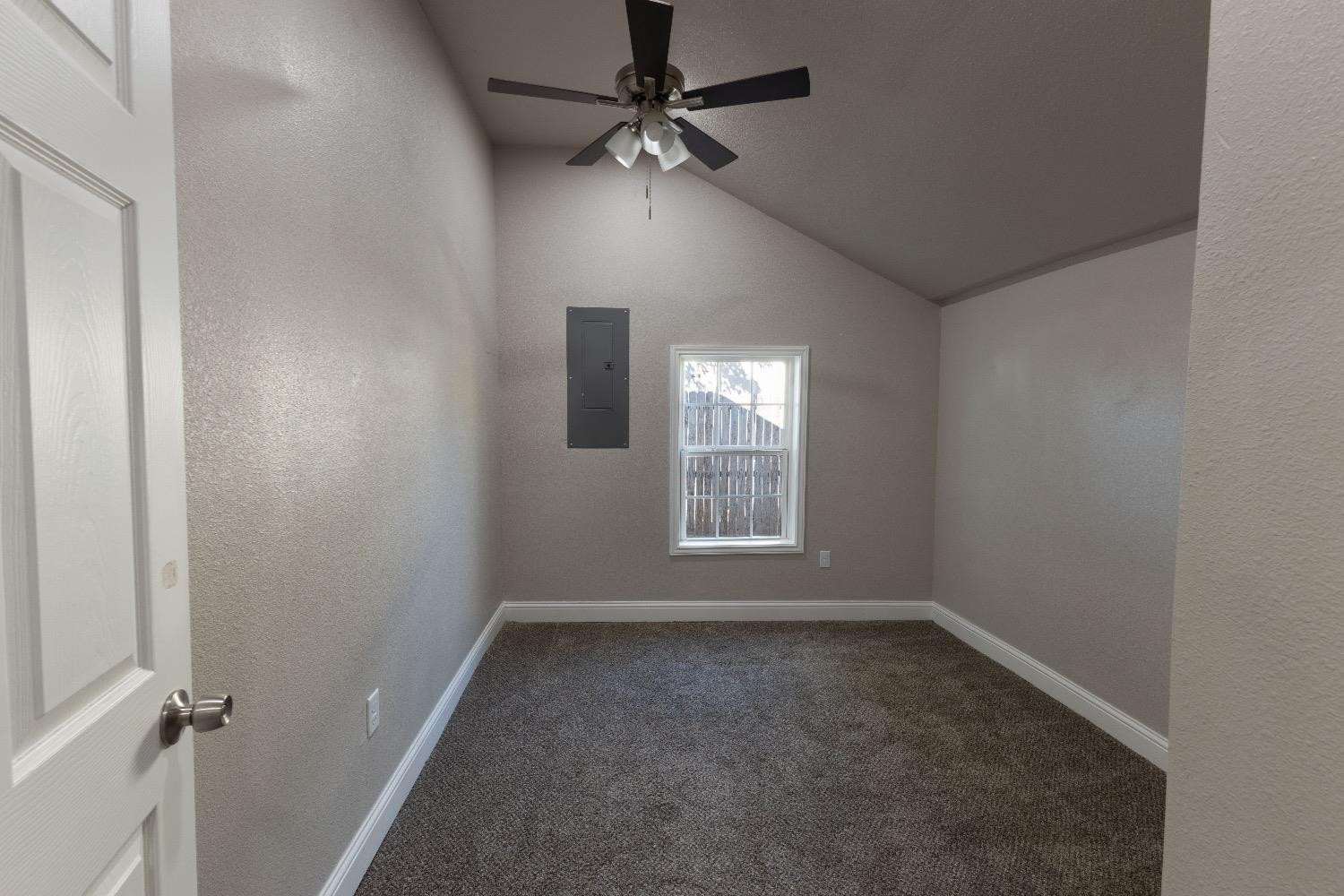 506 40th Street Lubbock, TX 79404 - Photo 7 of 17 an empty room with a window and a fan