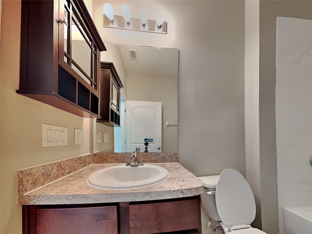 Undisclosed Address Spring Hill, FL 34609 - Photo 15 of 17 a bathroom with a granite countertop sink and a mirror
