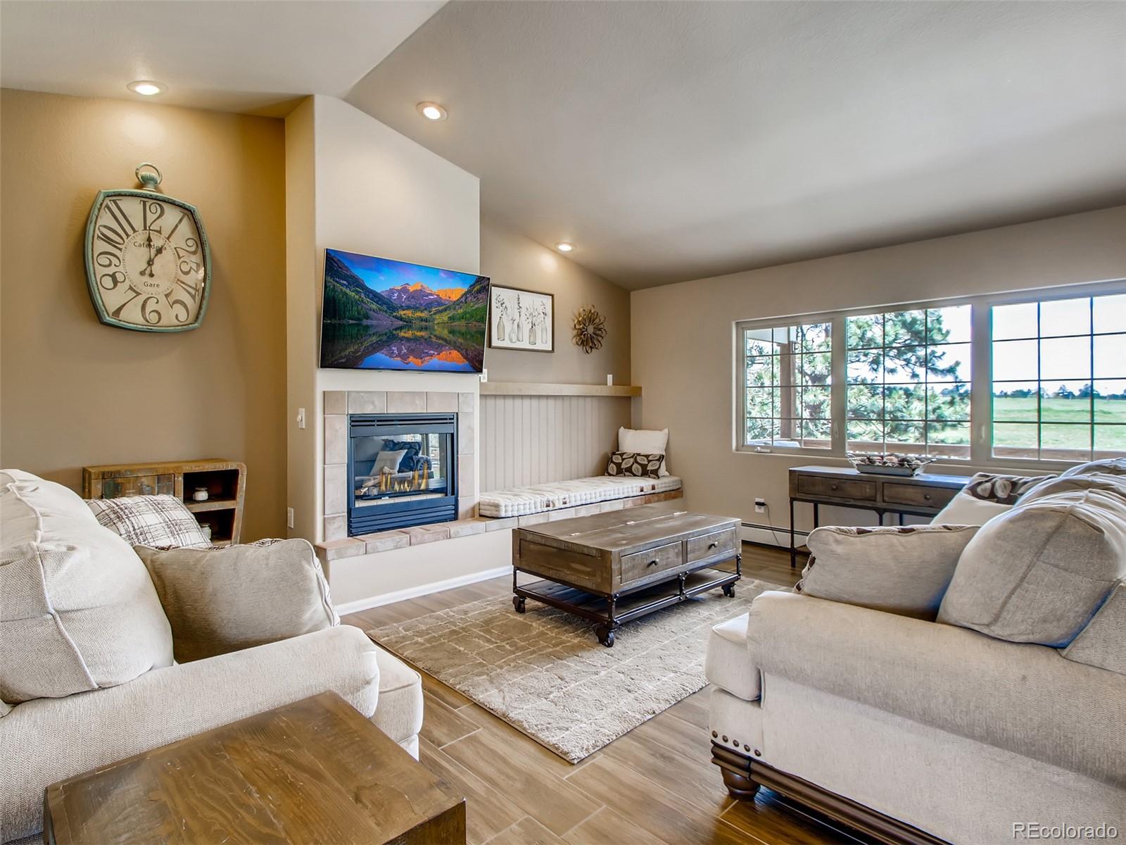 a living room with furniture a fireplace and a large window