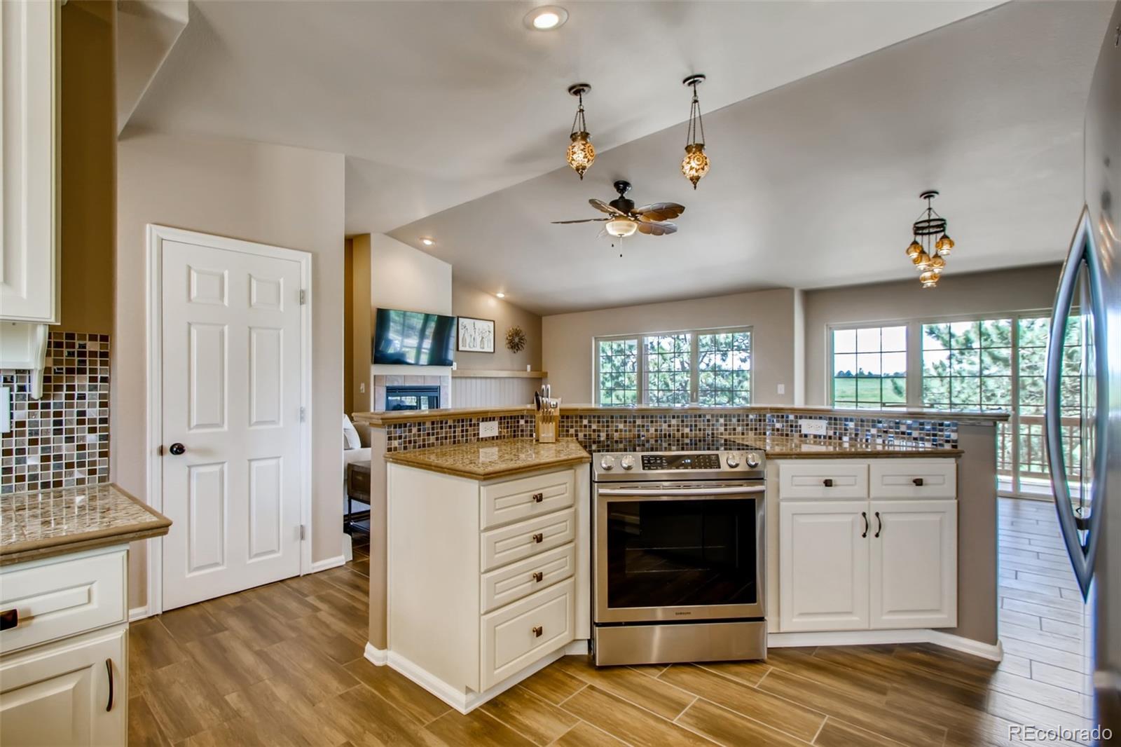 18030 Ranch Hand Road Peyton, CO 80831 - Photo 15 of 40 a kitchen with stainless steel appliances granite countertop a stove and cabinets